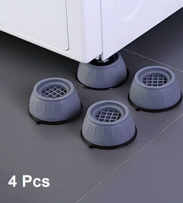 Four gray rubber furniture glides on a floor with a piece of furniture partially visible.